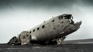 An abandoned and decaying airplane in a post-apocalyptic, barren landscape.