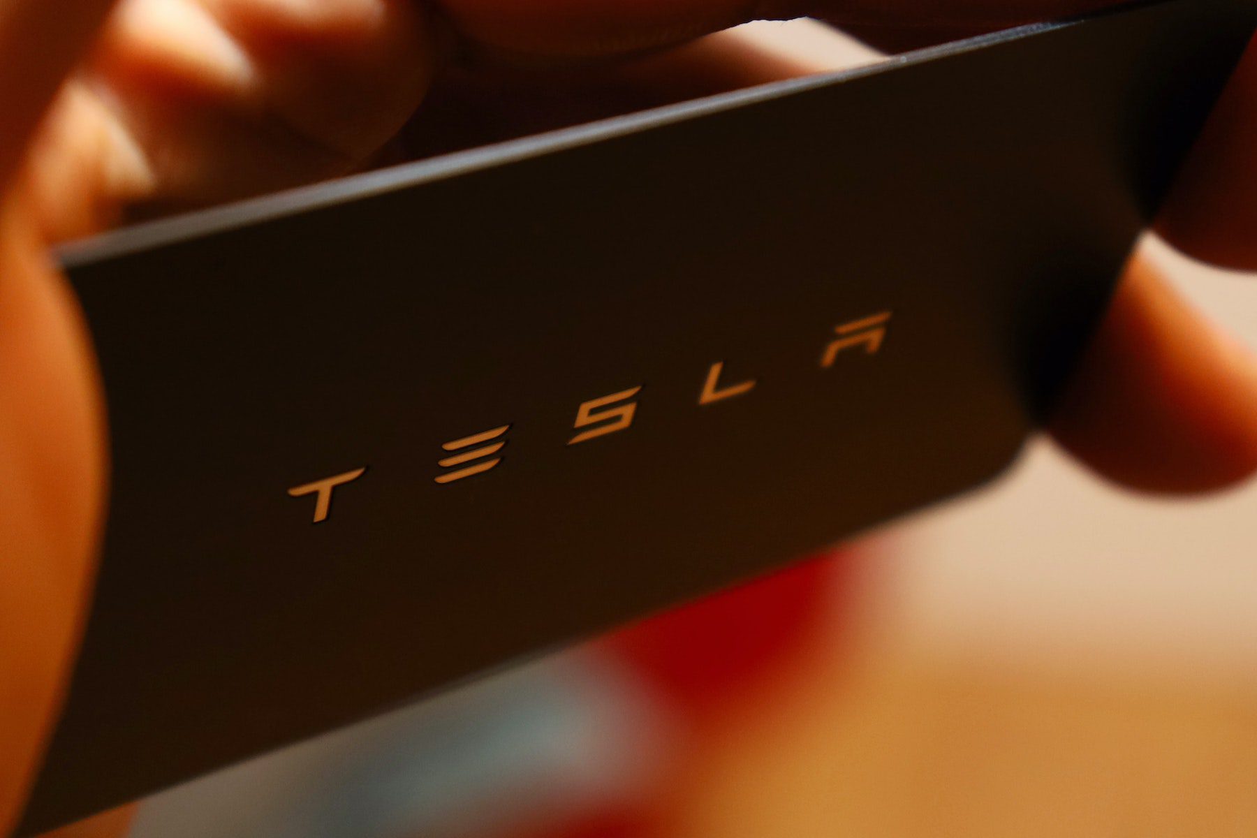 The Tesla logo embossed on a thin black card
