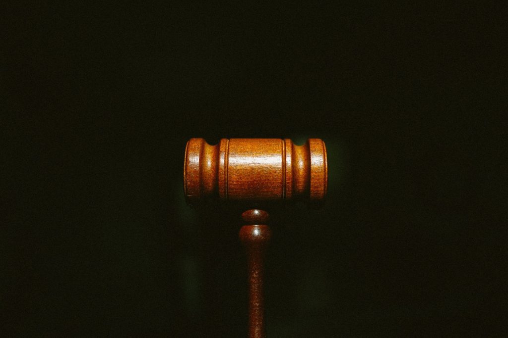 A courtroom gavel against a black background.