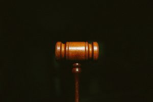 A courtroom gavel against a black background.