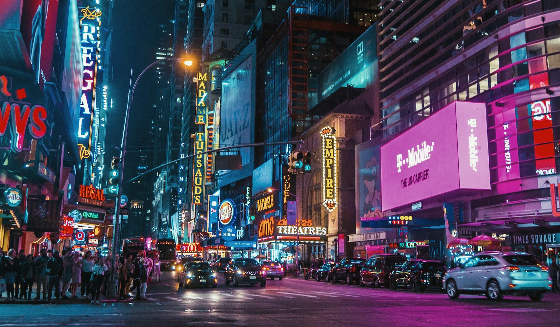Times Square in New York at night, illuminated in neon. 