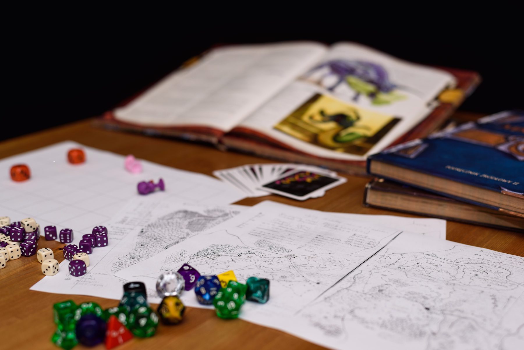 Various dice such as D20 as well as normal 6-sided dice, are laid across sheets of paper outlining a quest for dungeons and dragons. 