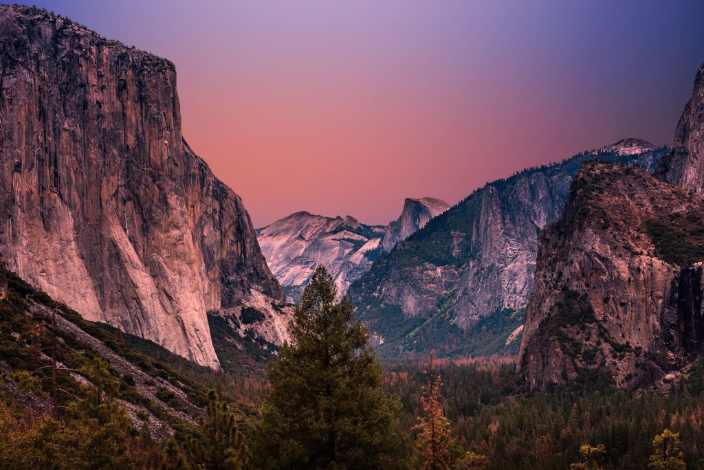 Mountains in Yosemite National Park, United States, during sunset and with a purple-pink filter applied.