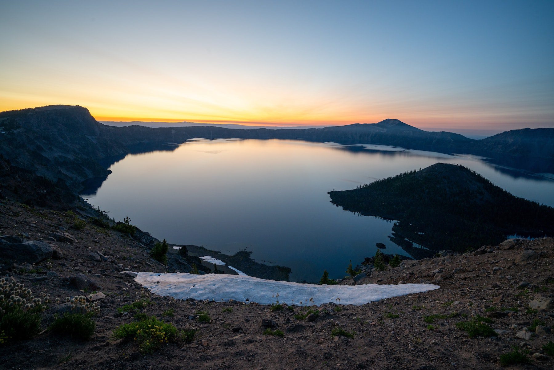 Sunrise over Crater Lake, a caldera in the national parks system, during the spring or summer season. 