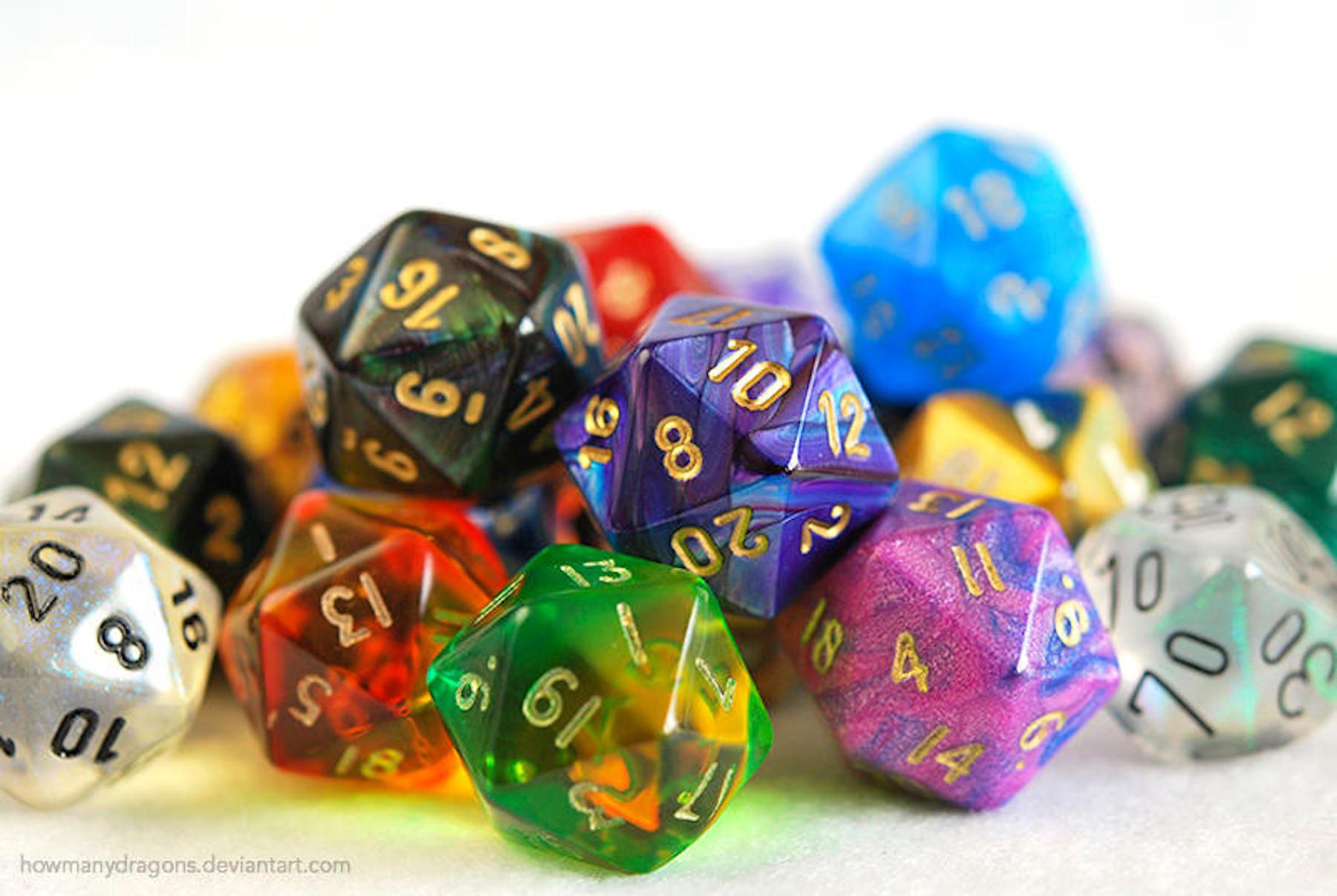 A pile of variously colored D20 dice against a white tabletop and plain white background.
