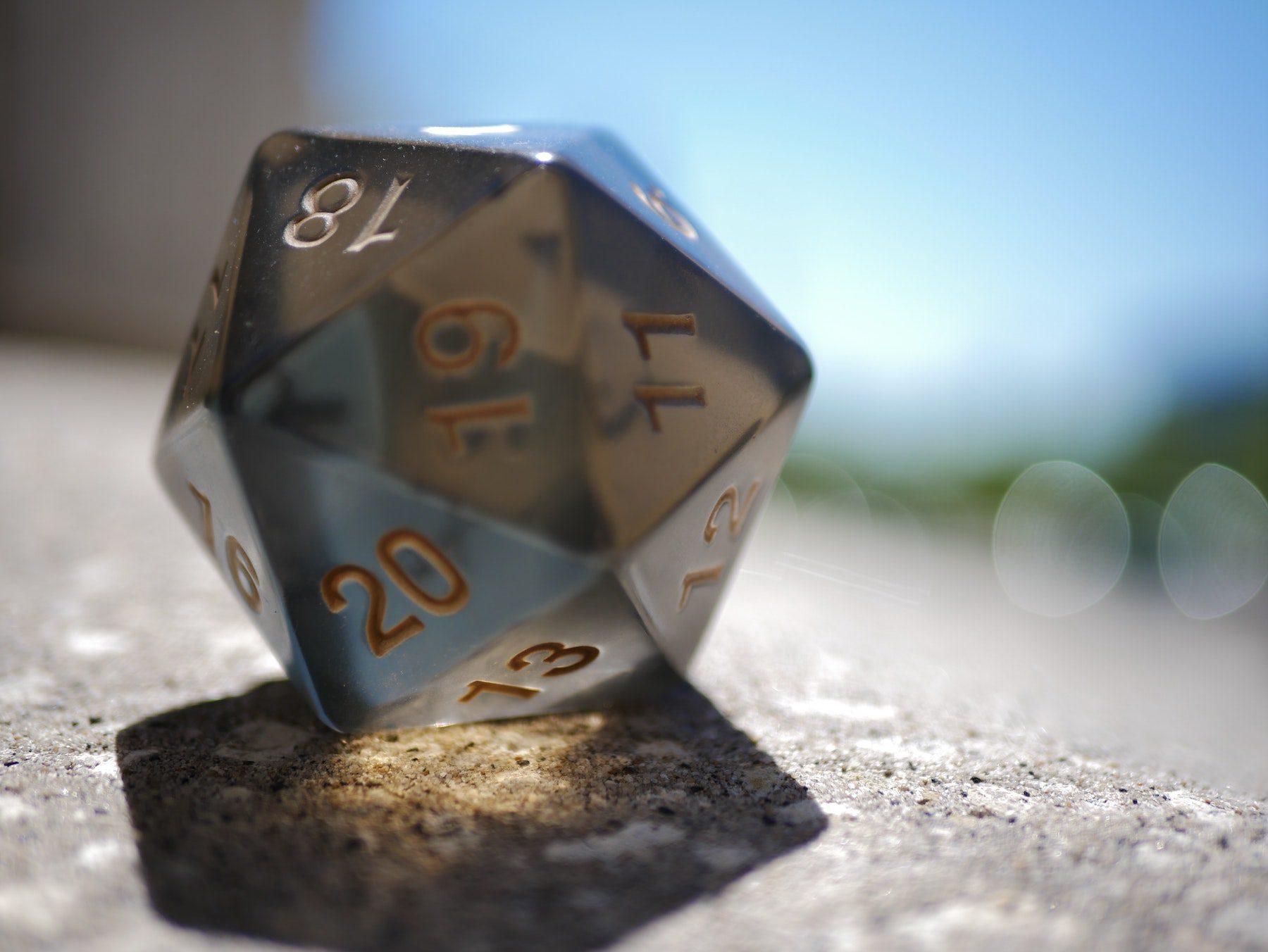 An opaque D20 dice, as used in the tabletop game Dungeons & Dragons, on a sunny windowsill.