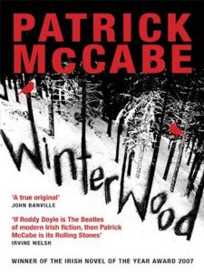 Cover for Winterwood by Patrick McCabe featuring illustration of snowy woods in black and white with red text and accents. 
