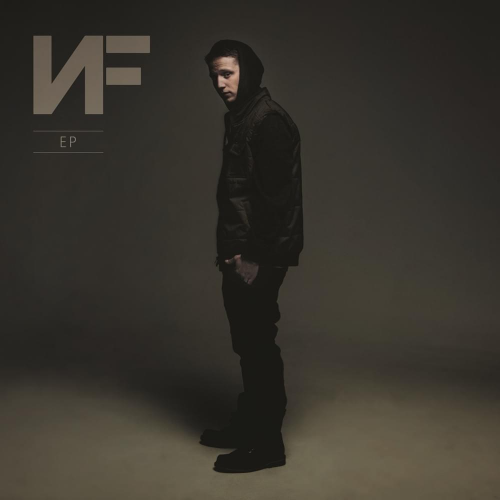 NF album cover art. Picture showing Nate Feuerstein in black jeans with a black hoodie and a down vest against a dark grey background