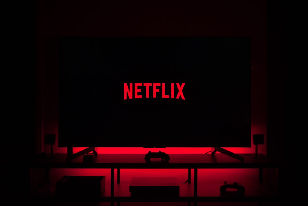 Netflix logo and a dark tv screen backlit with a red ambient light